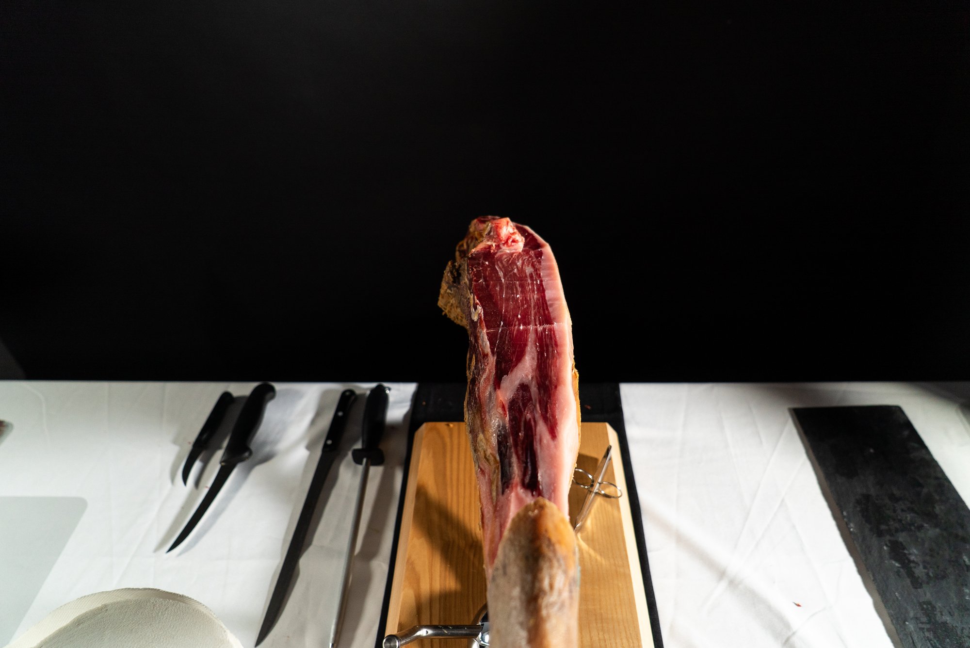 Pieza de jamón en el soporte con los cuchillos alineados