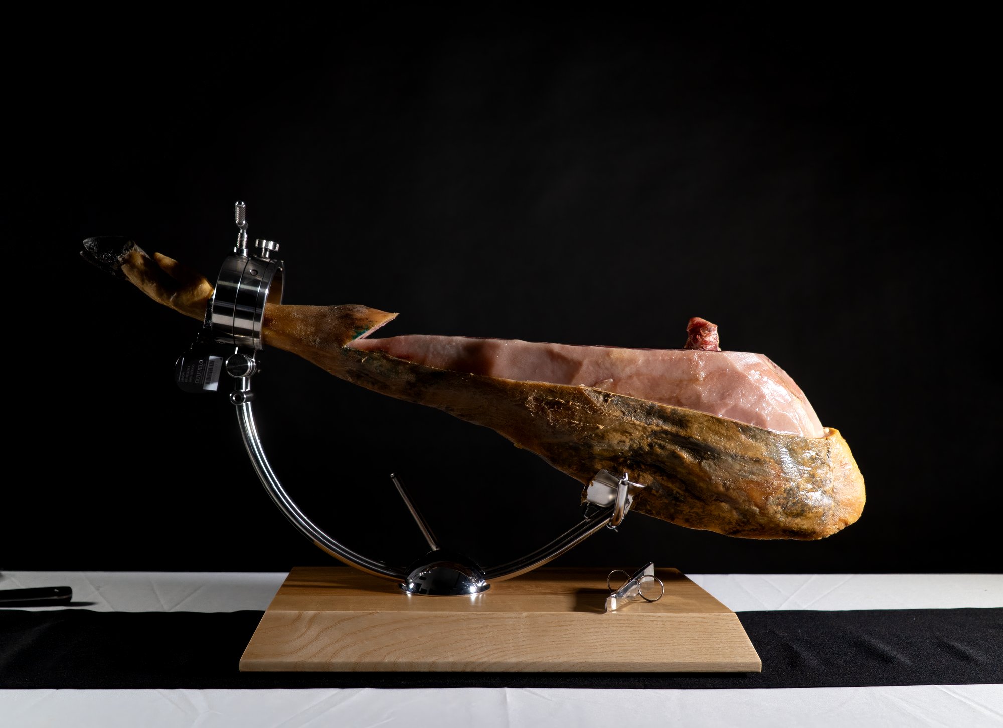 Pieza de jamón cortada en el jamonero, vista de perfil